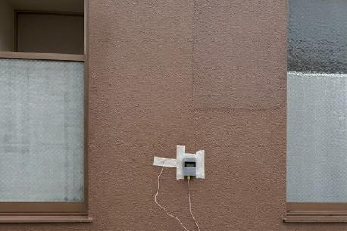 赤外線外壁調査で外壁に取り付けた表面温度計と、塗り直された外壁のパッチ