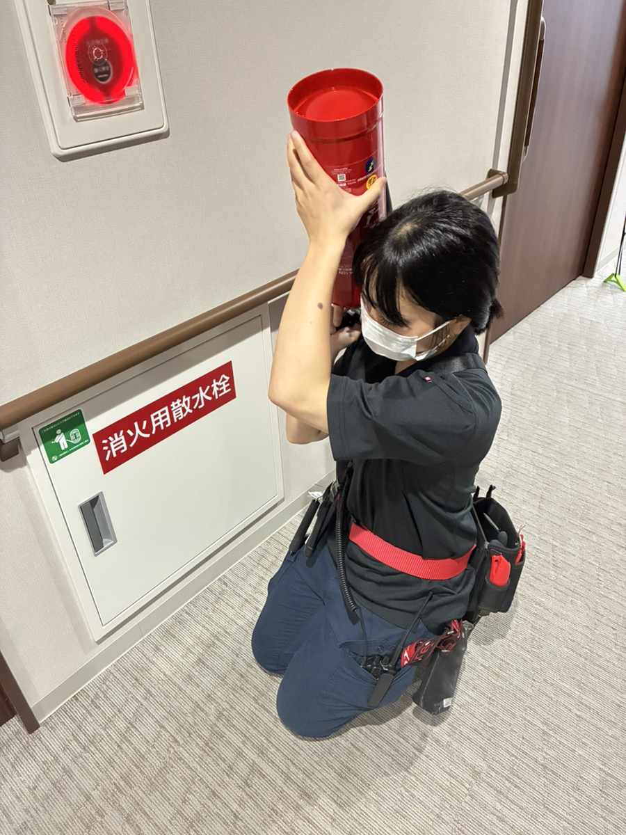 女性消防設備士の草地が消火用散水栓の点検を行う様子
