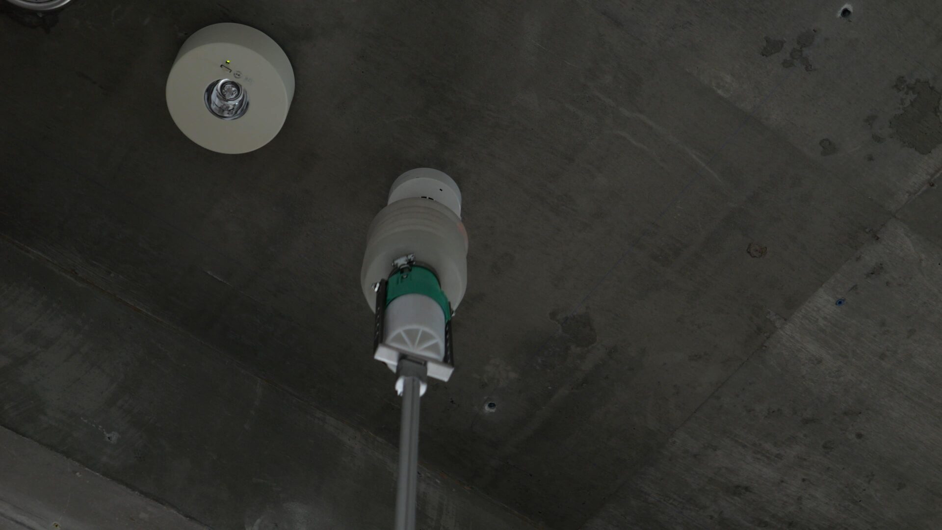 加熱試験器を使って天井の熱感知器の作動試験を行っている様子